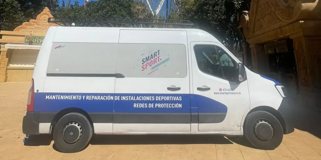 Furgoneta blanca de Smart Sport rotulada con mantenimiento y reparación de instalaciones deportivas y redes de protección